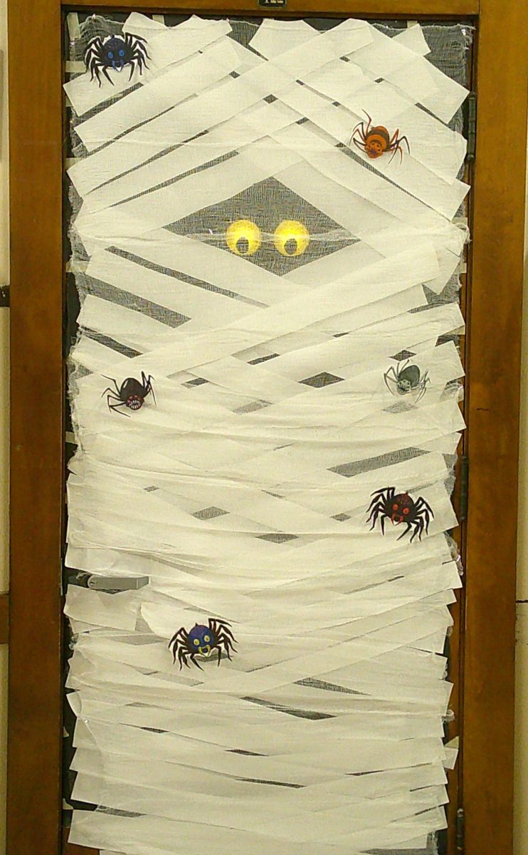 The door for Ms. Rocha's Room 422 is wrapped to resemble a spooky mummy, featuring glowing eyes and spider cutouts, for the Bay View High School Halloween door decorating contest in Milwaukee, Wis., on Thursday, Oct. 31. Ms. Rocha's fourth-hour Academic Strategies students created the decoration.