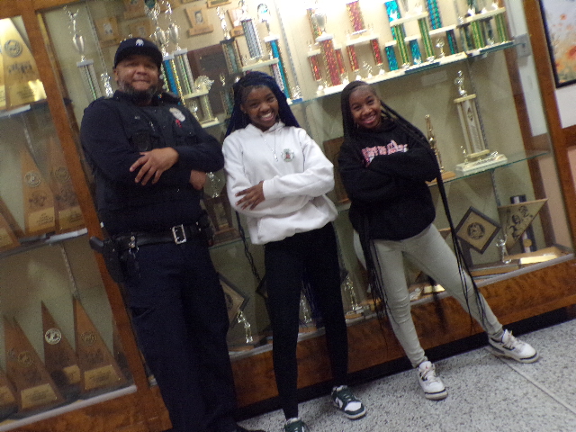School Resource Officer Bell spends time in the hallways building connections with juniors Nakijah Sanders and Dtarriya Mimms, fostering positive relationships with students throughout the school.
